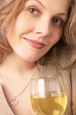 Smiling woman holding glass of white wine