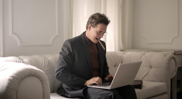 man smoking on sofar with laptop